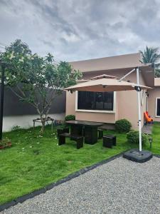 a patio with an umbrella and a picnic table at 185 HomeStay Chiangmai 185 โฮมสเตย์ เชียงใหม่ in Hang Dong