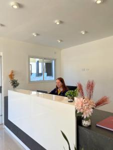 a woman sitting at a desk in an office at Hotel Storge in Villa Carlos Paz +28 photos