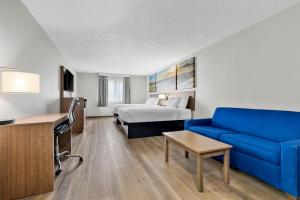 a hotel room with a blue couch and a bed at Quality Inn Sheridan in Sheridan +44 photos