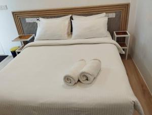 two rolled towels are sitting on a bed at Island Hospitality in Himandhoo 