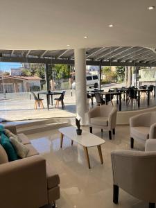 a living room with couches and a table and chairs at Hotel Storge in Villa Carlos Paz