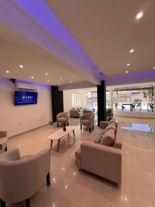 a living room with couches and chairs and a tv at Hotel Storge in Villa Carlos Paz
