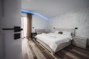 a bedroom with a white bed and a blue light at Alpine Retreat in Borsa