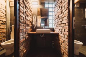 a brick walled bathroom with a sink and a toilet at Alpine Retreat in Borsa +29 photos