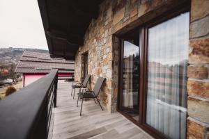 a balcony with chairs and a brick wall at Alpine Retreat in Borsa