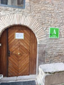 a wooden door on a stone building with a sign at Albergue de Ruesta in Ruesta +3 photos
