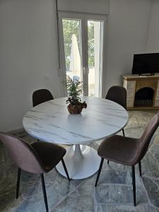 a white table with chairs and a potted plant on it at Ioannis Appartements Glossa in Glossa