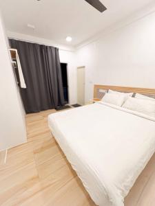 a bedroom with a white bed and a wooden floor at Island Hospitality in Himandhoo 