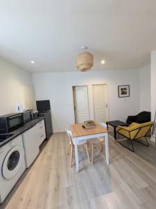 a living room with a table and a kitchen at Appartement La Jungle in Villebois