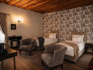 a hotel room with two beds and two chairs at Generalis Wine Hotel in Tokaj +57 photos