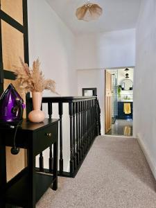 a hallway with a black table with a vase on it at Cardiff Mini Retreat in Cardiff