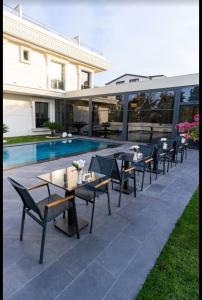 a patio with tables and chairs next to a pool at Rossa Marin Hotel in Darıca +6 photos