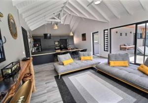a living room with two couches and a kitchen at EDEN FOREST VILLA in Pointe-Noire