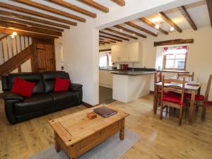 a living room with a couch and a table at Bwthyn Y Wennol in Llanddulas