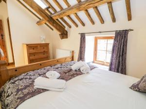 a bedroom with a bed with towels on it at Bwthyn Y Wennol in Llanddulas