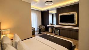a hotel room with a bed and a flat screen tv at Rossa Marin Hotel in Darıca