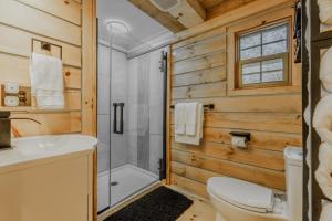 a bathroom with a shower and a toilet and a sink at Starry Nights in the Smokey Mountains with Hot Tub Pet Friendly Cabin A in Elizabethton +49 photos