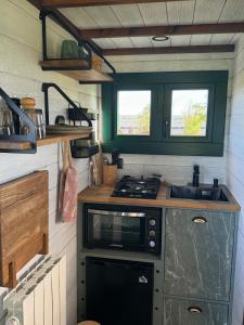 a small kitchen with a stove and a sink at Entre ciel et champs in Capendac