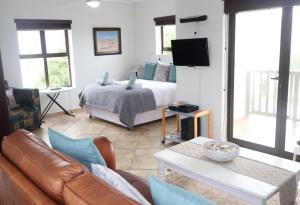 a living room with a bed and a couch at Beachway on Golden Mile in St. Helena Bay +25 photos