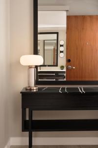 a desk with a mirror and a lamp on it at Loews Chicago Hotel in Chicago +127 photos