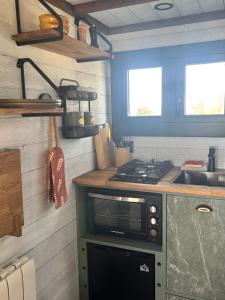 a small kitchen with a stove and a sink at Entre ciel et champs in Capendac +7 photos