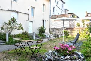 a patio with a table and chairs and an umbrella at Appartement - Washington 3 in Le Havre