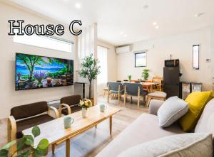 a living room with a house c sign on the wall at HOTEL StayLuck KOTOHIRA - 琴平駅徒歩4分 in Kotohira