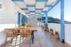 a patio with a wooden table and chairs on a balcony at Khōra Suites Matala in Matala