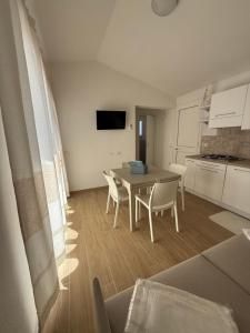 a kitchen and dining room with a table and chairs at Residence Le Onde in Badesi