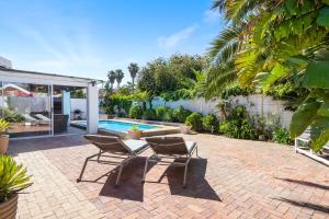 a patio with a table and chairs and a swimming pool at Ravens 9A in Bloubergstrand