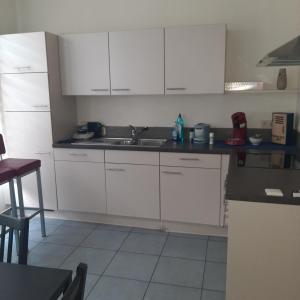 a kitchen with white cabinets and a sink at Italian stile in Spa