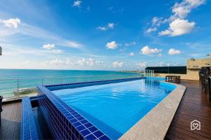 a swimming pool on the roof of a building with the ocean at Mar Bello in Ilha da Restinga
