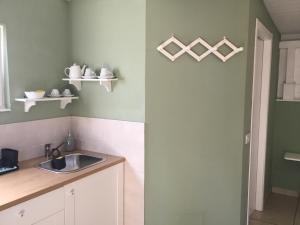 a kitchen with a sink and a counter with shelves at Villa Ghirardelli in Sirolo