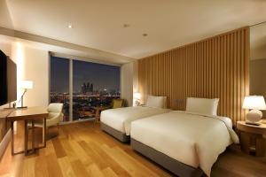 a hotel room with two beds and a large window at Hotel Entra Gangnam in Seoul