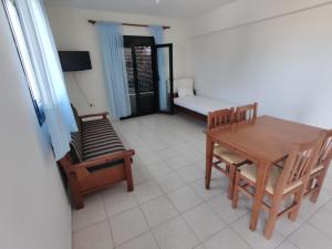 a living room with a table and chairs and a couch at Panorama Apartment 1 in Moúdhros