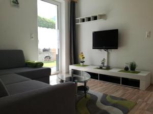 a living room with a couch and a flat screen tv at Apart Eila in Pfunds