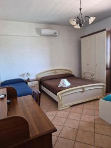a bedroom with a bed and a desk and a table at Villa Malandrino Guest House in Agropoli