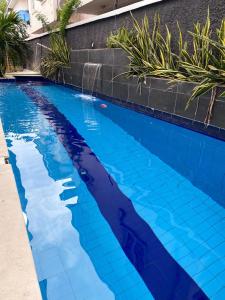 a swimming pool with blue tiles on the side of a house at Declevor Homes in Lekki