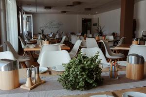 a restaurant with wooden tables and white chairs at Schlossberghotel Greiz in Greiz