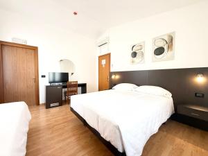 ein Hotelzimmer mit zwei Betten und einem Fernseher in der Unterkunft Hotel Gran Casa in Oderzo + 51 Fotos