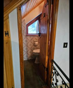 a bathroom with a toilet and a window at Baita degli Alpini in Terminillo
