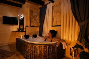 a woman in a bath tub in a room at Üçhisar Palace İn Cappadocia in Uçhisar