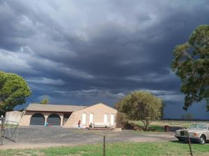 a church under a cloudy sky with a car at Dubbo Farm in Dubbo