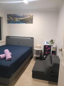 a bedroom with a blue bed and a couch at Dubbo Farm in Dubbo +39 photos