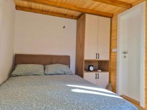 a bedroom with a bed and a wooden ceiling at Kućica na jezeru in Jezero