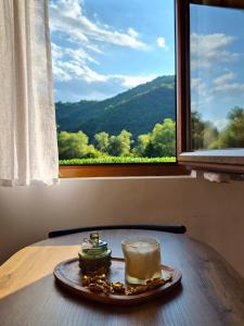 a plate with a coffee cup on a table in front of a window at Kućica na jezeru in Jezero