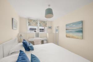 a bedroom with a white bed with blue pillows at 114 North Street in St. Andrews
