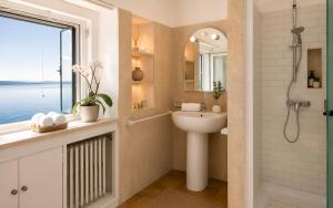 a bathroom with a sink and a shower and a window at Villa Coccodrilla in Toscolano Maderno