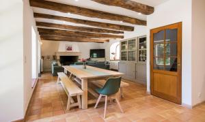 a kitchen and dining room with a wooden table and chairs at L'Oustal del Sully - Villa d'exception avec piscine, proche lac de Pareloup in Prades-Salars