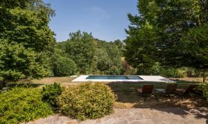 a swimming pool in a yard with two chairs at L'Oustal del Sully - Villa d'exception avec piscine, proche lac de Pareloup in Prades-Salars